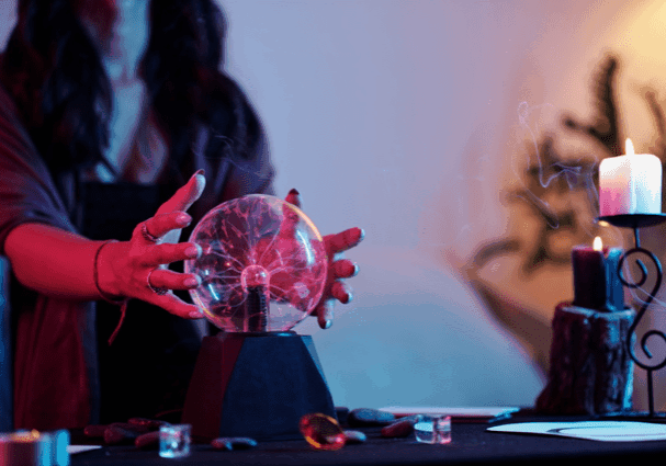 Person with crystal ball and lit candle.