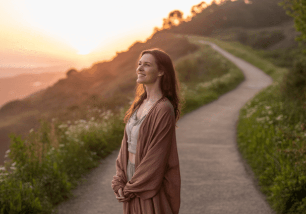 Woman enjoying a sunset on a path.